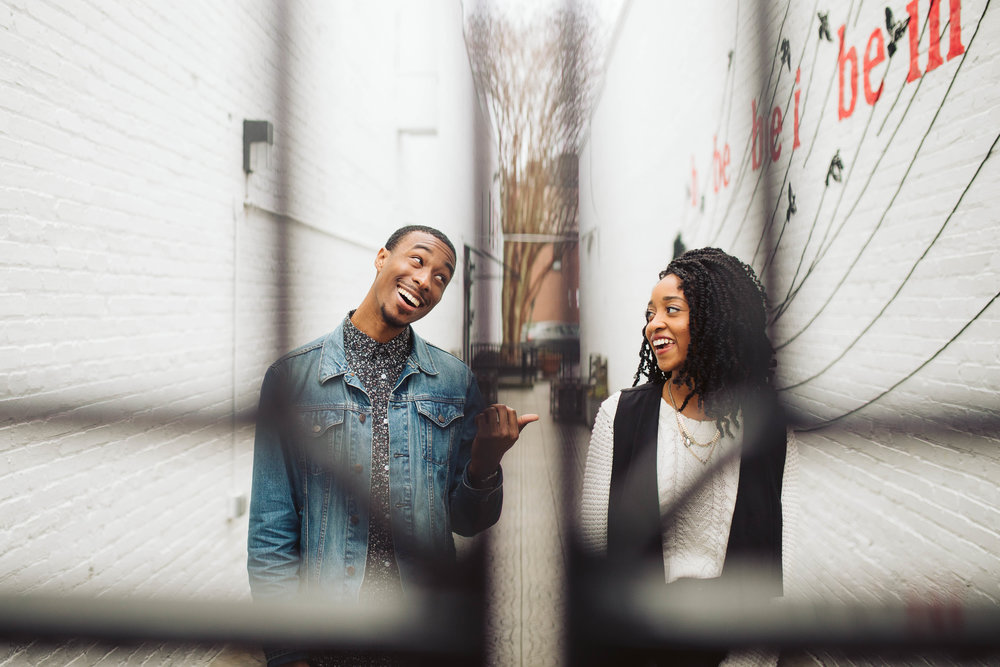  engagement shoot with couple in alley through metal gate 