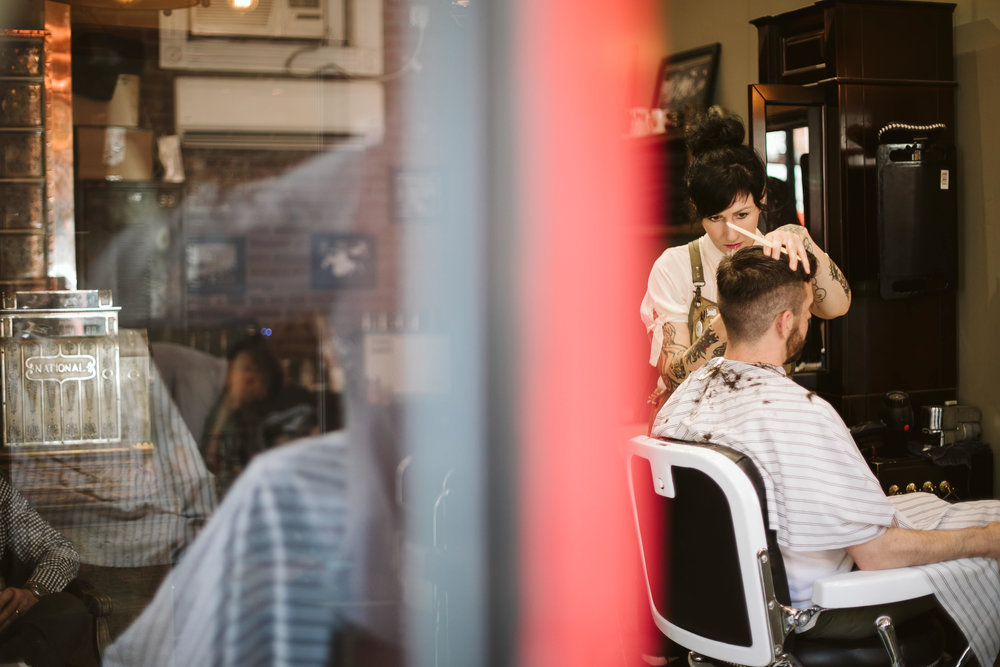  The groom getting a pre-wedding haircut at the barber shop at this Battello Wedding in Jersey City, NJ 