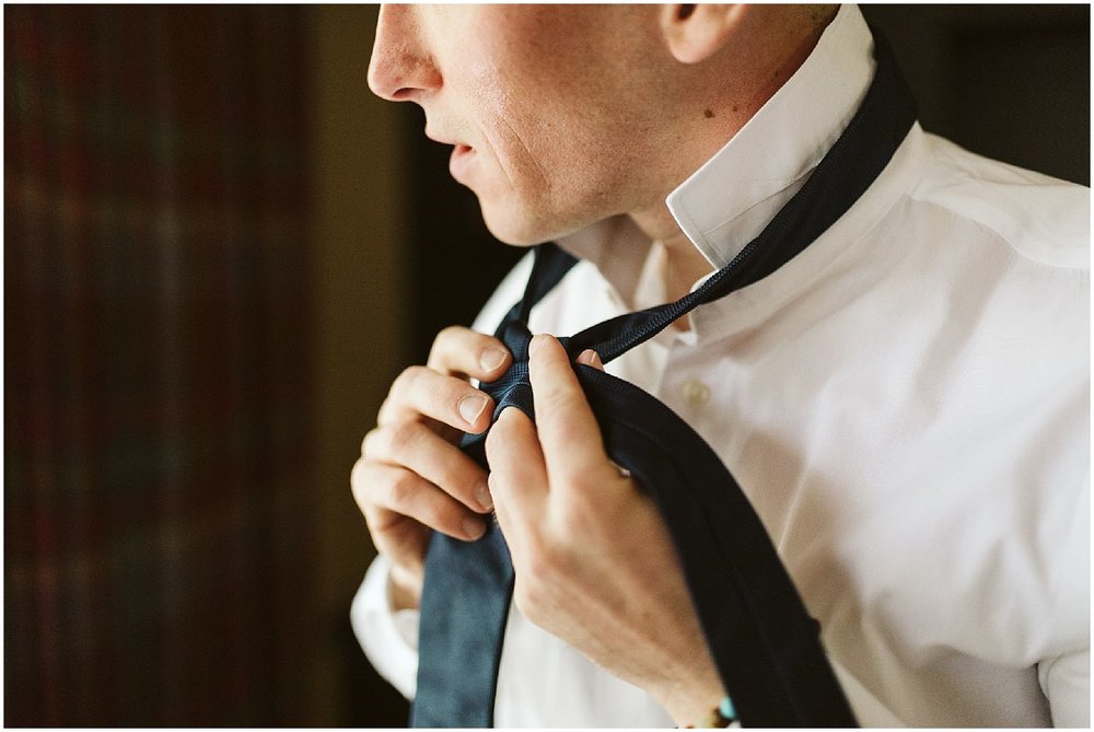  groom tying his tie 