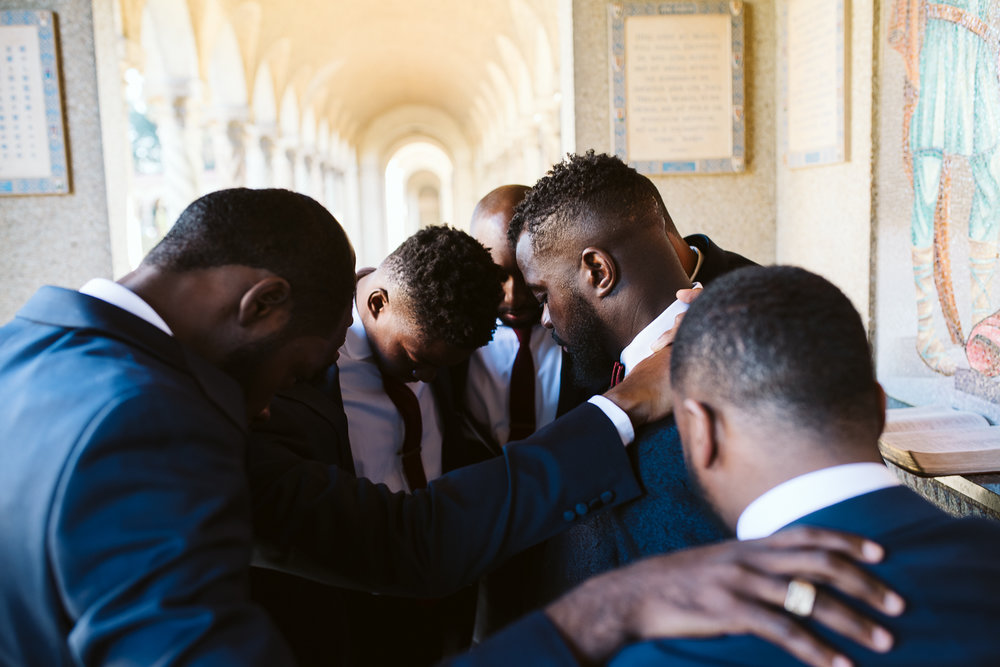  groomsmen praying before st francis hall wedding 