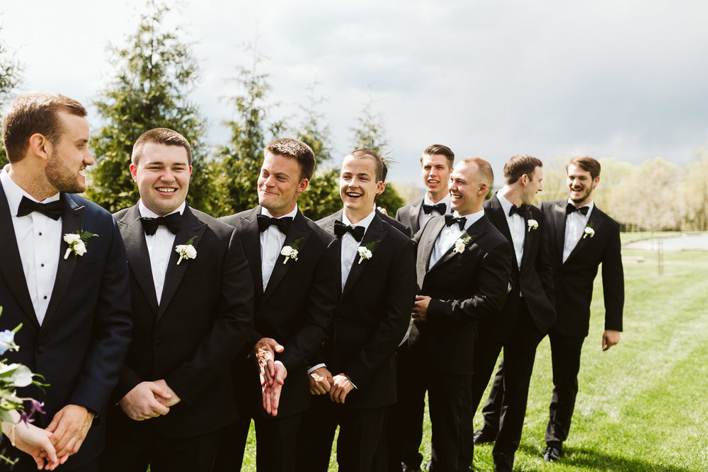  groomsmen wearing black suits outside 