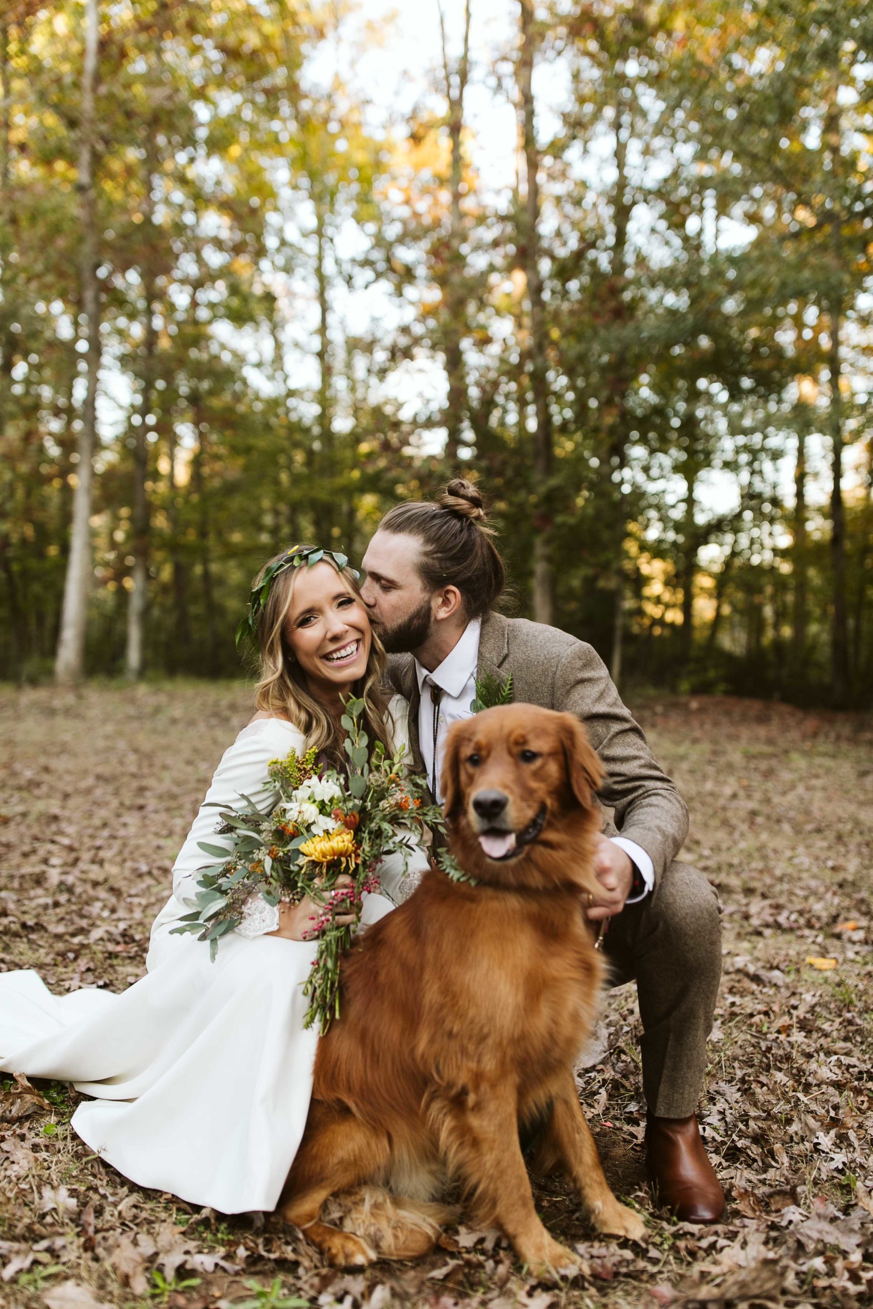 couple poses with golden retriever at wedding