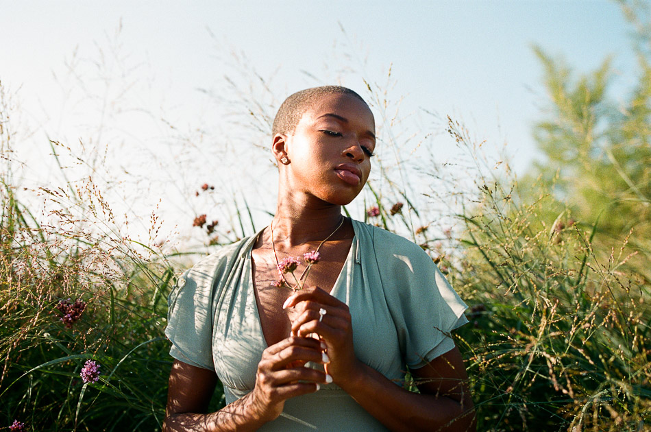 Black woman surrounded by tall grass photographed on film