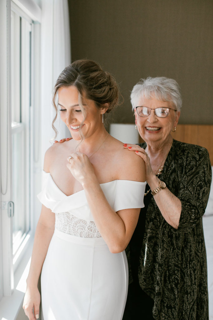 grandmother puts necklace on bride on wedding day