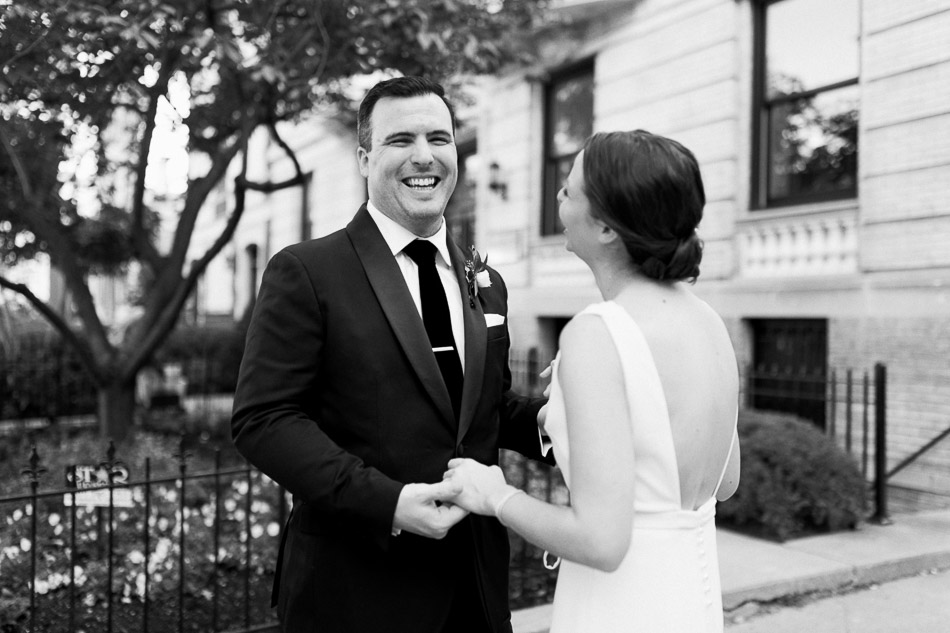 black and white photo of groom smiling during first look at  intimate wedding at the national cathedral