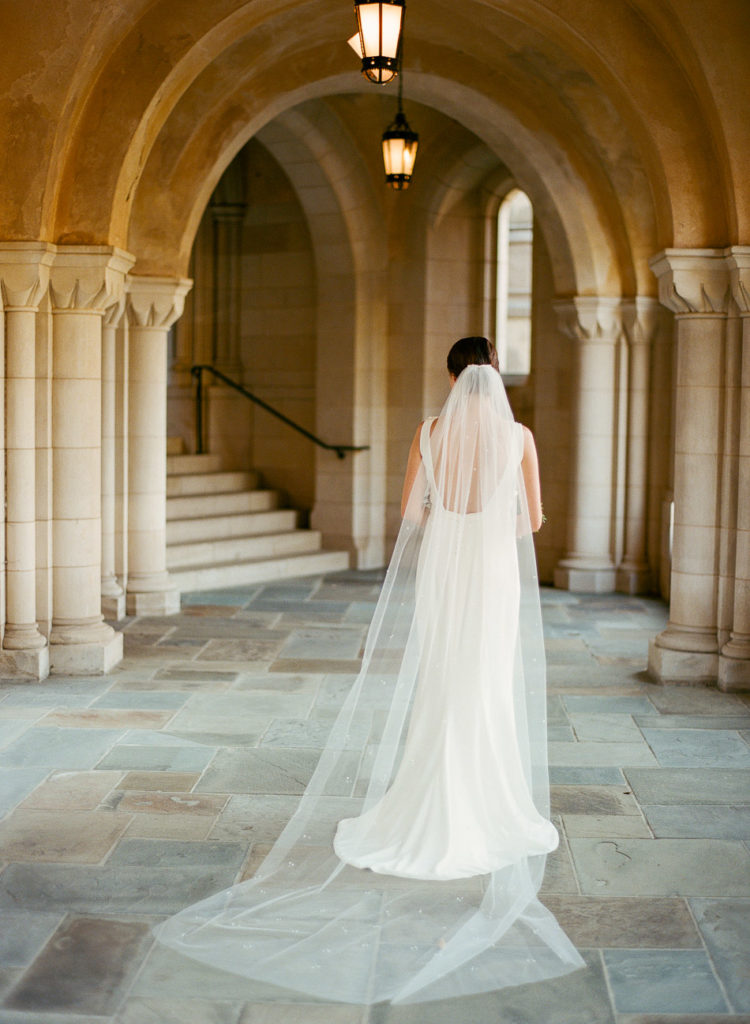 bride stands near the stairs at intimate wedding at the national cathedral