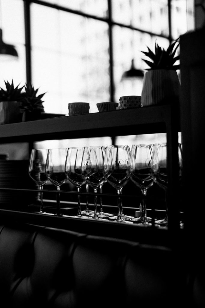 black and white photo of wine glasses during engagement session at goodstone inn
